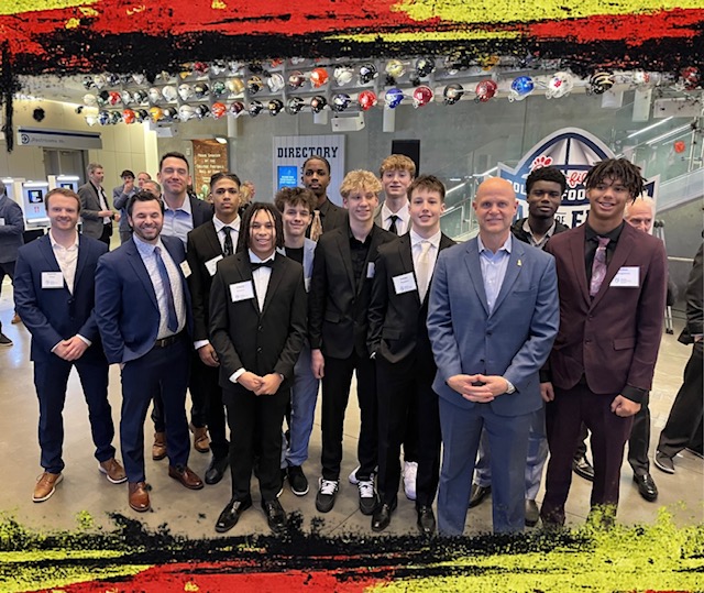 Danny Wuerffel standing with players in suits at the Wuerffel Trophy banquet