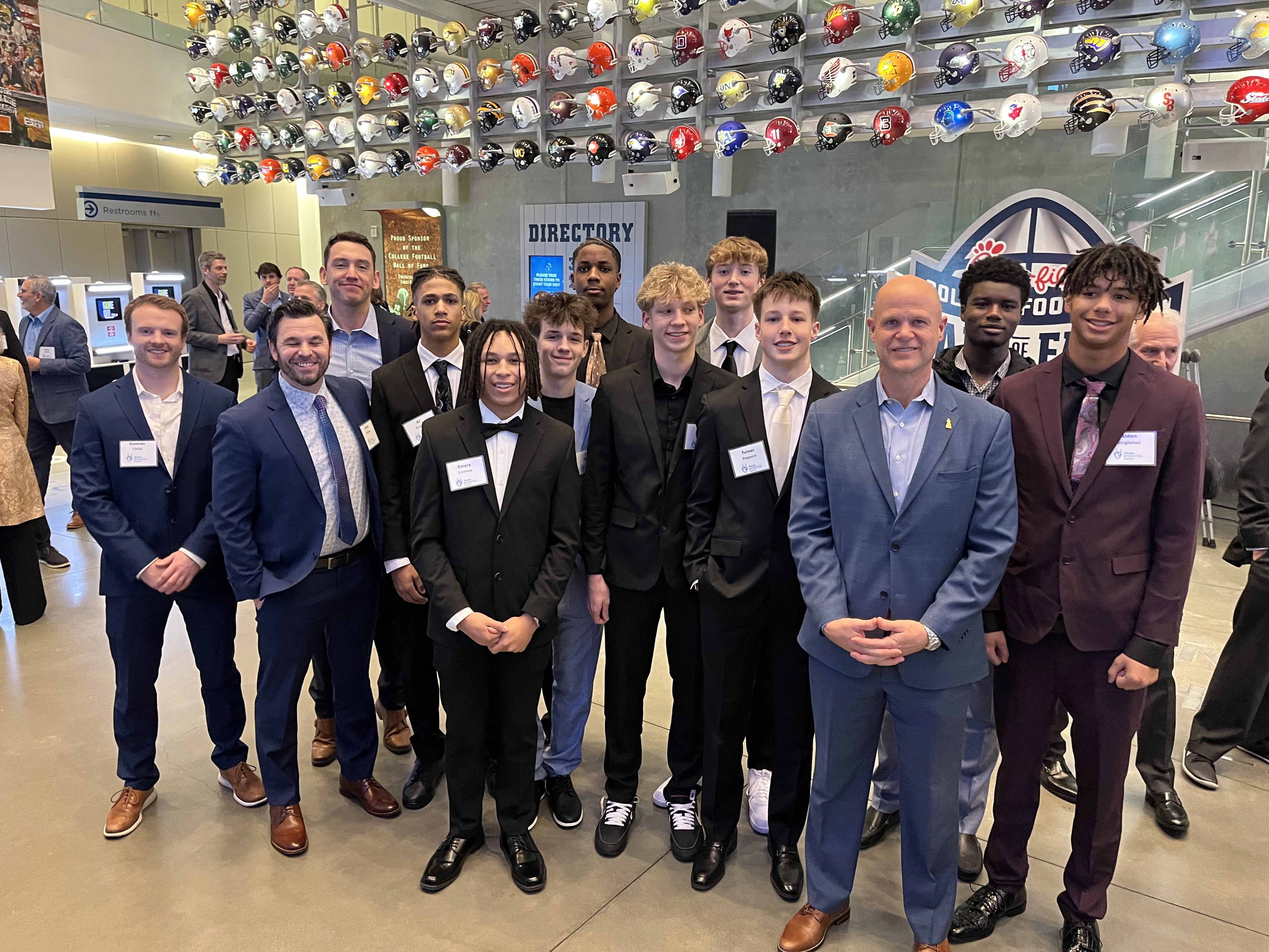 15U team group photo at College Football Hall of Fame with helmet display